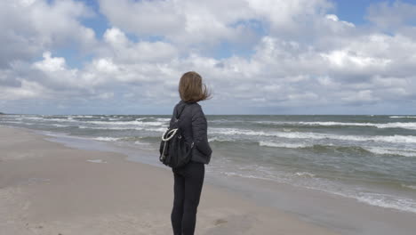 Cinematic-shot-of-woman-admiring-the-ocean-and-the-waves