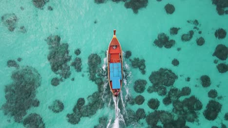 Aerial-tracking-shot-of-a-small-motorboat-near-Ko-Lipe,-Thailand-on-a-bright-clear-day