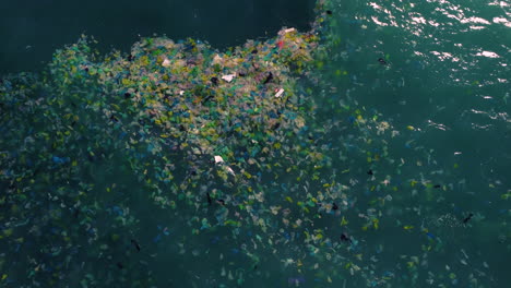 Aerial-top-down,-ocean-water-polluted-with-plastic-ocean-trash-floating-on-surface