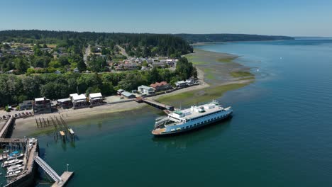Drone-shot-of-a-small-commuter-ferry-off-the-shore-of-Langley,-Washington