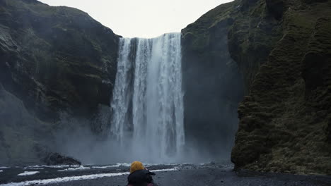 Woman-in-front-of-Skogafoss,-in-Iceland