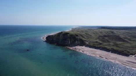 The-well-known-cliffs-of-bulbjerg-on-the-north-sea-in-denmark,-filmed-from-the-sea-with-a-drone,-breathtaking-scenery