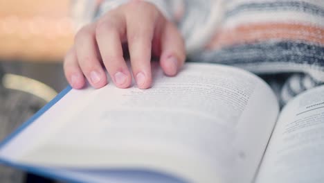 Close-up-of-person's-fingers-and-hand-following-lines-they-read-in-a-book