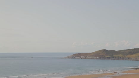 Woolacombe-Bay-Beach-with-Baggy-Point-and-People-Swimming-Hot-Summers-Day