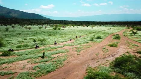 Turistas-Montando-Motocicletas-Viajando-Hacia-El-Lago-Magadi-En-Kenia---Toma-Aérea-De-Drones