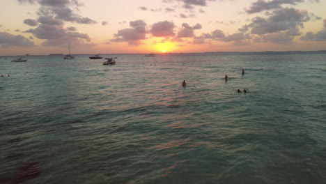 Menschen-Am-Strand-Im-Türkisfarbenen-Karibischen-Wasser-Bei-Sonnenuntergang
