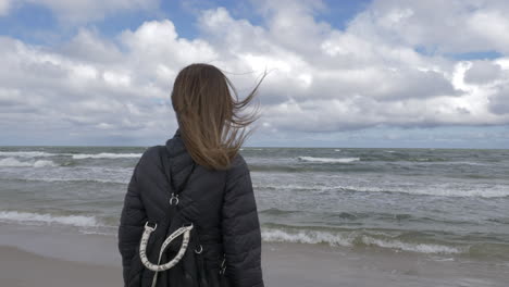 Cinematic-shot-of-woman-admiring-the-ocean-in-Slowinski-National-Park,-Poland