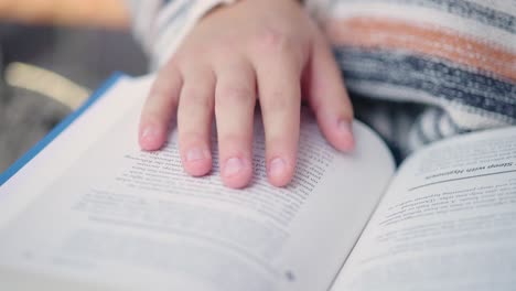 Close-up-of-girl's-fingers-following-lines-she-reads-in-a-book