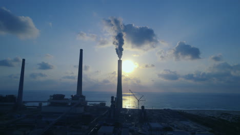 Luftaufnahme-Eines-Kraftwerks-Mit-4-Schornsteinen,-Von-Denen-Einer-Dicken-Rauch-In-Die-Luft-Abgibt-Und-Die-Energie-In-Israel-Verschmutzt