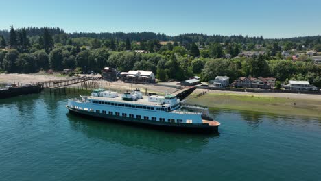 Aerial-view-of-a-small-seafaring-ferry-moored-on-the-shore-of-Langley,-Washington