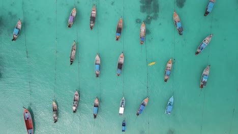 Aerial-top-down-dolly-shot-pulling-away-from-a-group-of-boats-anchored-off-of-Ko-Lipe-Island,-Thailand