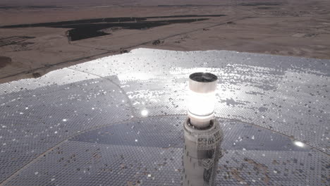Solarturm-Fokussiertes-Sonnenlicht-Für-Bewegliche-Spiegel-In-Der-Wüste-An-Einem-Wolkenlosen-Tag---Nahaufnahme,-Heruntergeklappter-Drohnenwagen-In-Schuss
