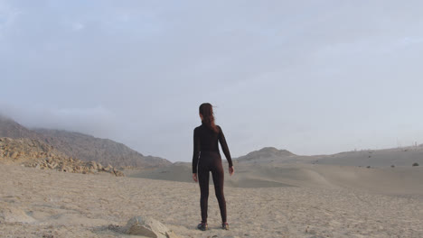 Long-back-shot-of-a-mysterious-woman-in-black-standing-in-the-middle-of-the-desert