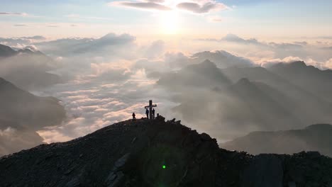People-standing-on-a-mountain-and-enjoying-the-sunrise