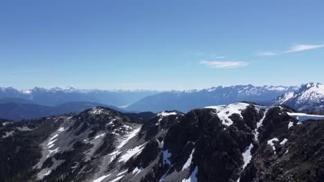 Paisaje-De-Montaña-Elegante-Aumento-Lento-Revelar-Drone-Aéreo-Con-Cielo-Azul-Brillante-Y-Nieve-Cordilleras-Del-Pacífico-Canadá-4k