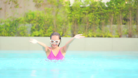 Happy-Exotic-Woman-With-Wet-Hair-is-Playing-With-Water-in-Swimming-Pool-of-Luxury-Tropical-Resort,-Slow-Motion