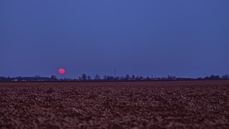 Timelapse-of-the-moon-is-a-bright-crimson-color-as-it-ascends-into-the-sky