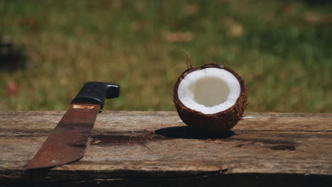 A-coconut-shell-on-a-bench-with-a-machete-that-chopped-it-in-half