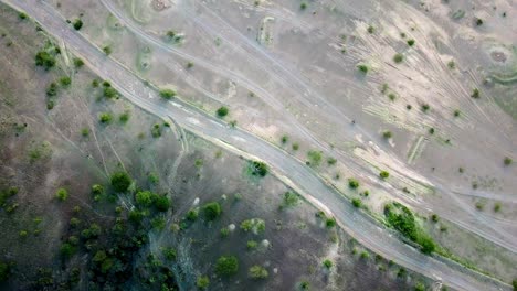 Top-down-View-Of-African-Landscape-With-Motorcycle-Traveling-Towards-Lake-Magadi-In-Kenya---drone-shot