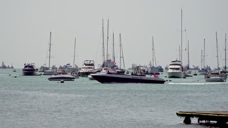 Statische-Aufnahme-Von-Segelbooten,-Die-An-Der-Küste-Angedockt-Sind,-Und-Einem-Motorboot,-Das-An-Einem-Hellen-Sonnigen-Tag-In-La-Punta,-Callao,-Peru-Vorbeifährt