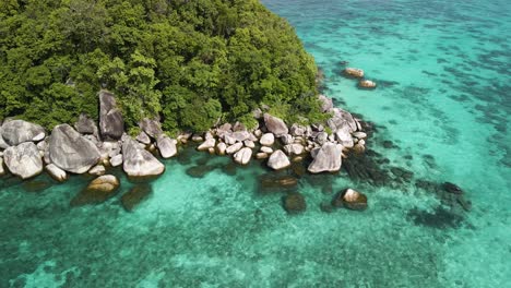 Aerial-arc-shot-circling-around-an-outcropping-of-an-island-near-Ko-Lipe,-Thailand-on-a-bright-afternoon