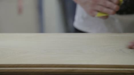 Hand-Sands-Down-Wooden-Plank-Ready-For-Building-Door-in-Workshop