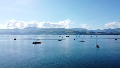 Snowdonia-clear-mountain-range-aerial-push-in-view-sunny-calm-Welsh-shimmering-seascape