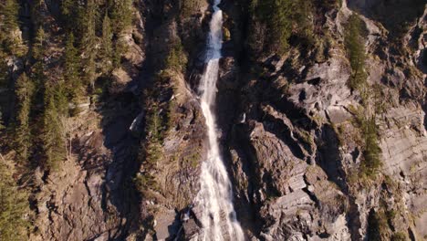 Aerial-drone-footage-panning-down-a-picturesque-waterfall-in-Grindelwald-in-the-Swiss-Alps