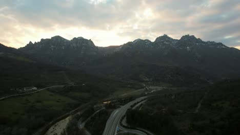 This-is-an-Italian-highway-with-barely-any-traffic,-filmed-during-a-beautiful-sunset-with-the-most-amazing-mountain-backdrop