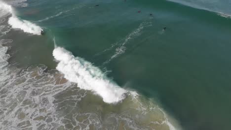 Dieses-Video-In-Superzeitlupe-Zeigt-Eine-Gruppe-Von-Surfern-Im-Ozean,-Von-Denen-Einer-Eine-Welle-Fängt-Und-Reitet