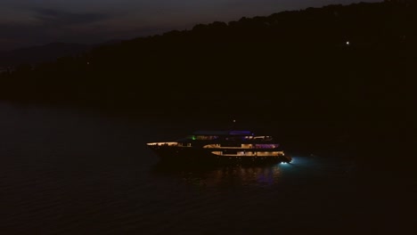 Yacht-near-island,-night-time
