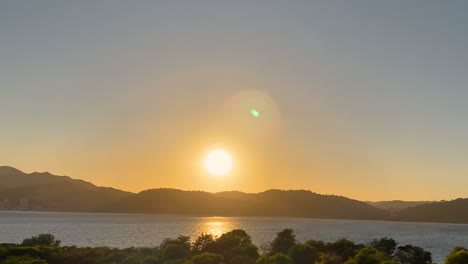 Luftaufnahme-über-Den-Wunderschönen-Sonnenuntergang-In-Outão,-Setúbal,-Portugal-Drohnenblick-Von-Troia-Auf-Den-Orangefarbenen-Sonnenuntergang-Mit-Meer-Und-Ufer
