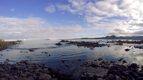 A-panning-time-lapse-shot-of-the-ocean-waters,-rocks,-and-sky-of-Kodiak-Island-Alaska