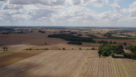 Aerial-Panoramic-View-Of-Vast-Farmland-Near-Countryside-Against-Beautiful-Cloudscape-Sky