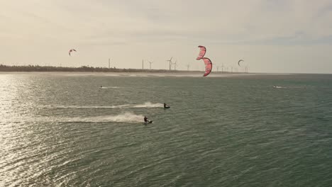 Zwei-Kitesurfer-Mit-Hoher-Geschwindigkeit-Durch-Meereswellen-Im-Sonnenuntergang