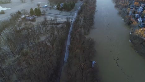 Aerial-of-neighborhood-in-Kentucky-USA-after-river-flooded-and-submerged-withered-trees-in-winter