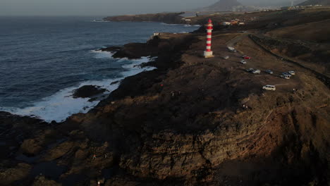 Aerial:-circling-around-the-famous-Faro-de-Sardina,-lighthouse-tower-in-Gran-Canaria