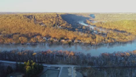 Aerial-of-debris-flowing-down-the-river-in-American-neighborhood-of-Kentucky-with-flooded-riverside-homes