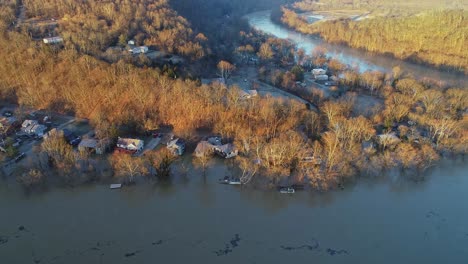 Aerial-top-down-view-of-deciduous-forest-with-flooded-riverfront-homes-in-Kentucky-USA-at-sunset