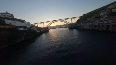 Low-level-FPV-shot-near-water-surface-of-Douro-river-by-Ribeira-neighborhood-of-Porto,-Portugal