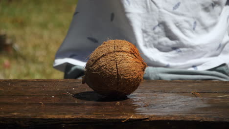 Slow-motion-of-man-chopping-fresh-organic-coconut-in-half-with-machete