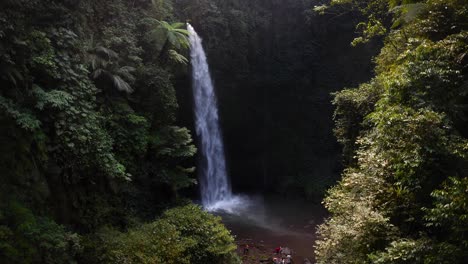 Touristengruppen-Genießen-Die-Fantastische-Aussicht-Am-Fuße-Des-Riesigen-Nung-Nung-Wasserfalls-Auf-Der-Indonesischen-Insel-Bali-Inmitten-Der-Dicht-Bewaldeten-Grünen-Natur