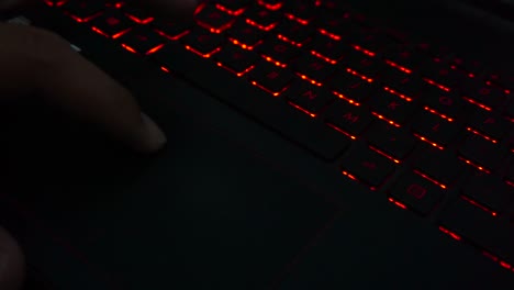 Close-up-shot-of-finger-make-move-on-the-laptop-pointer-pad-with-the-background-of-the-light-from-the-keyboard
