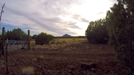 Eine-Zeitrafferaufnahme-Entlang-Eines-Stacheldrahtzauns-Und-Tors-In-Der-Wüstenwildnis-Von-Arizona