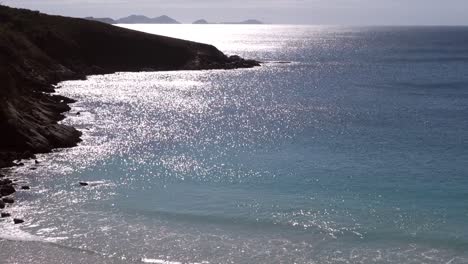 Morning-sun-rays-reflecting-on-sea-surface-at-mountain-bay