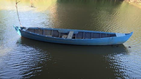 Small-blue-fishing-boat,-built-in-wood-and-traditional-from-Baixo-Mondego,-Portugal