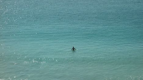 Man-swimming-lonely-in-clear-shallow-sea-water-at-sunny-morning