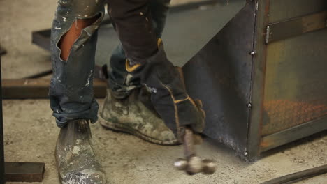 Steel-worker-using-heavy-hammer-mallet-to-ensure-the-best-smooth-edge-can-be-presented