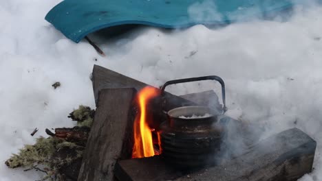 A-traditional-Australian-billy-boiling-water-over-a-fire-in-the-snow-of-Australias-alpine-region
