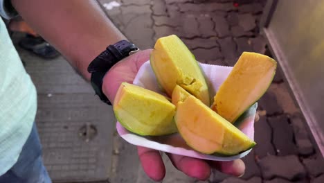 Video-De-Un-Hombre-Comiendo-El-Delicioso-Y-Cremoso-Kulfi-De-Mango,-Un-Helado-Indio-Similar-Al-Helado-De-Mango-Pero-Preparado-Con-Mango